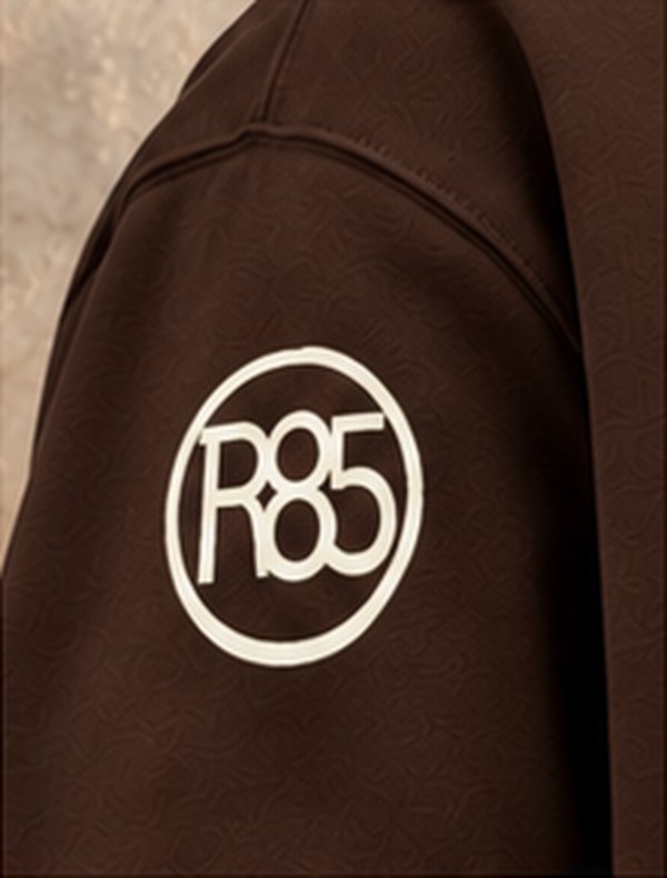 R85 circle on a brown hoodie sleeve