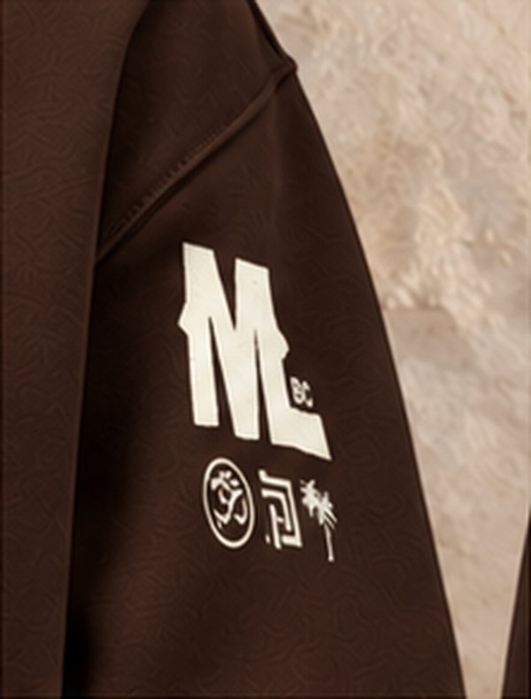 Mud & Lotus logo on a brown hoodie sleeve