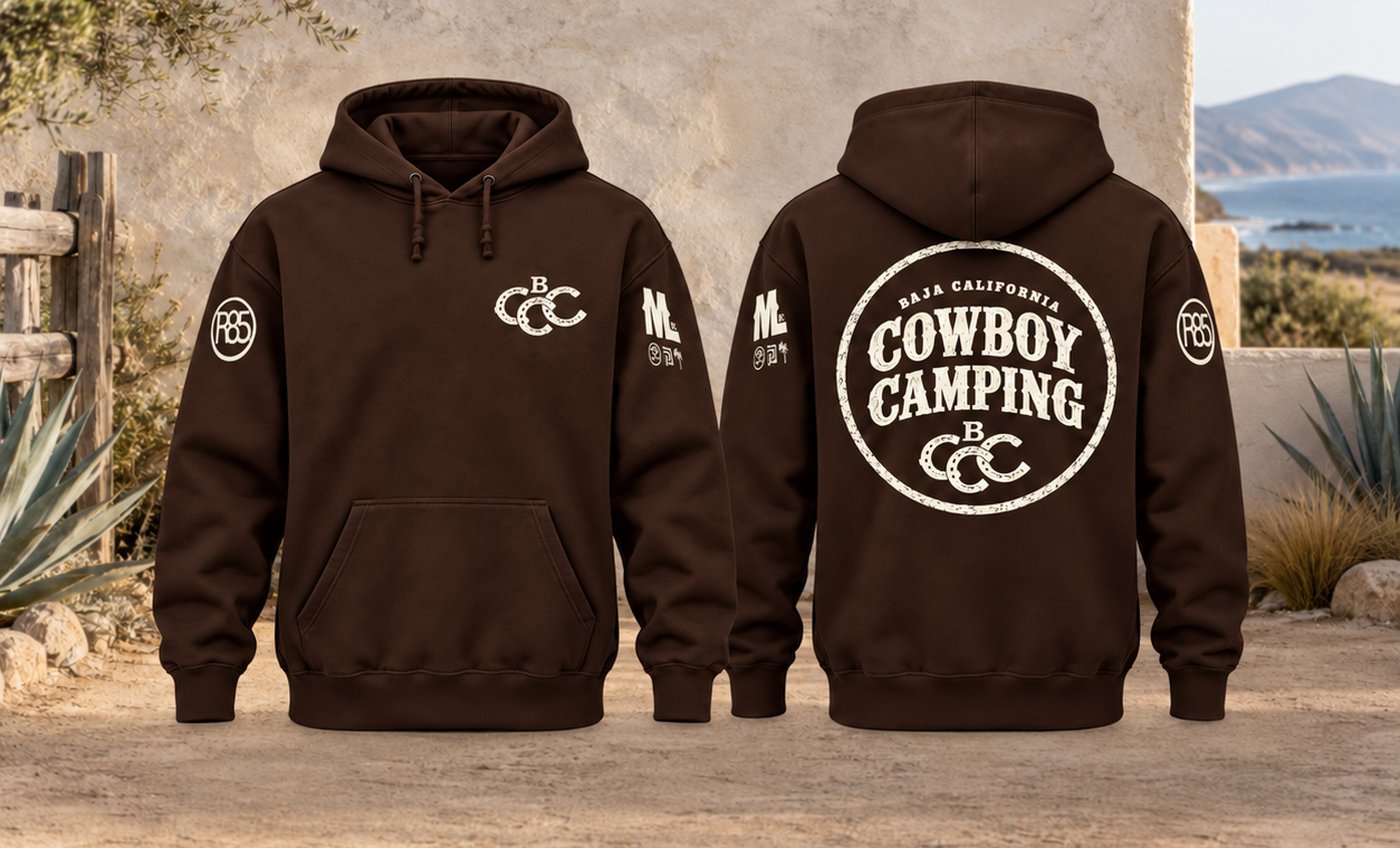 Front and back of the dark brown Baja California Cowboy Camping hoodie: horseshoe B-and-three-Cs on the chest, the round Cowboy Camping badge across the back, Rancho 85 and Mud & Lotus on the sleeves.